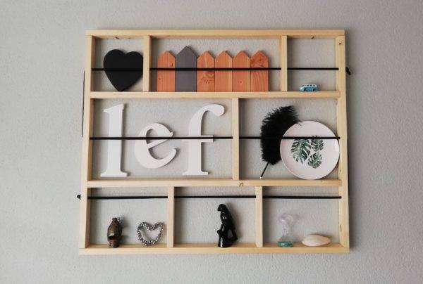 wanddecoratie van hout met elastiek waarachter je foto's etcetera kunt zetten
